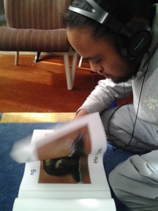 Hemi is reading and book with headphones on